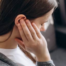 Young woman experiencing ear pain.