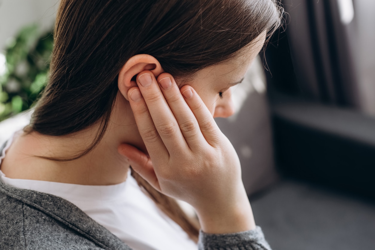 Young woman experiencing ear pain.