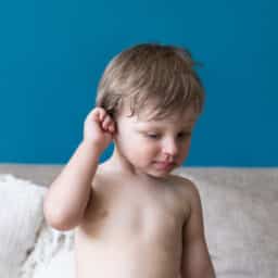 Young boy holds ear