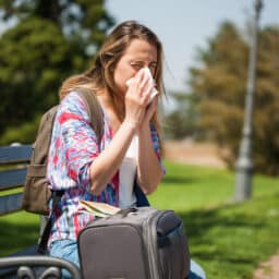 Woman with allergies sits in park
