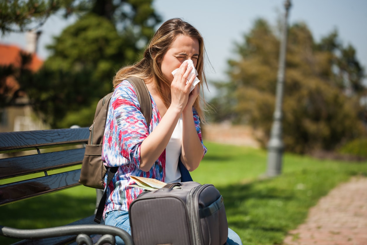 Woman with allergies sits in park