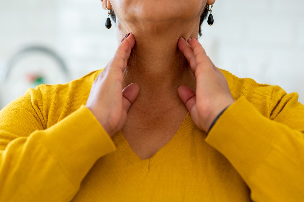 Woman feels sides of her neck